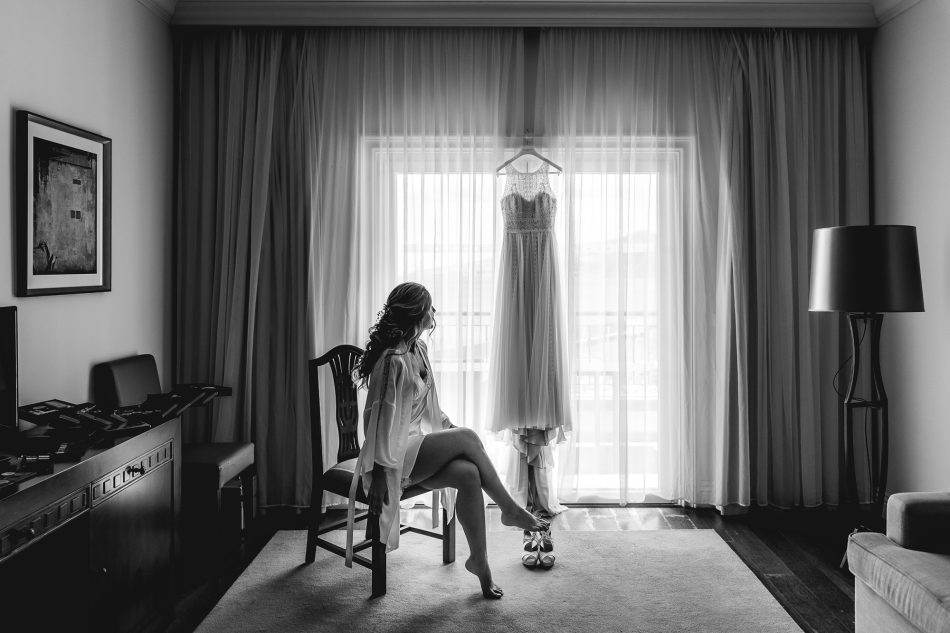 Bride in bridal gown looking at her wedding dress