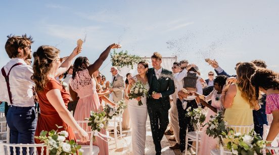 Wedding photo with the bride and groom leaving under a shower of confetti next to the chapel of Nossa Senhora da Rocha, in Armação de Pera, in the Algarve, Portugal